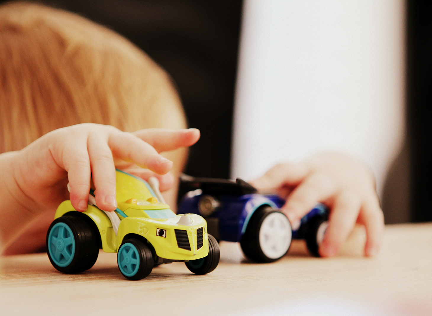behavioral child playing with toy cars